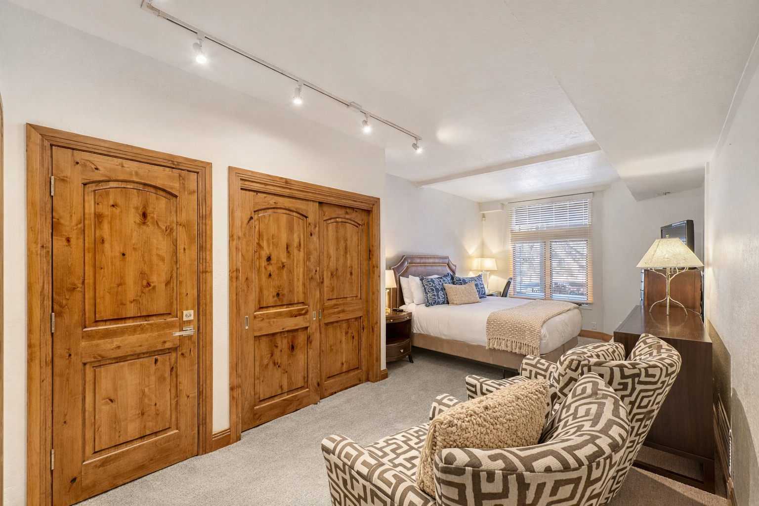 Relax in this peaceful bedroom retreat featuring a plush king bed, stylish decor, and warm lighting. A tranquil oasis for your stay.