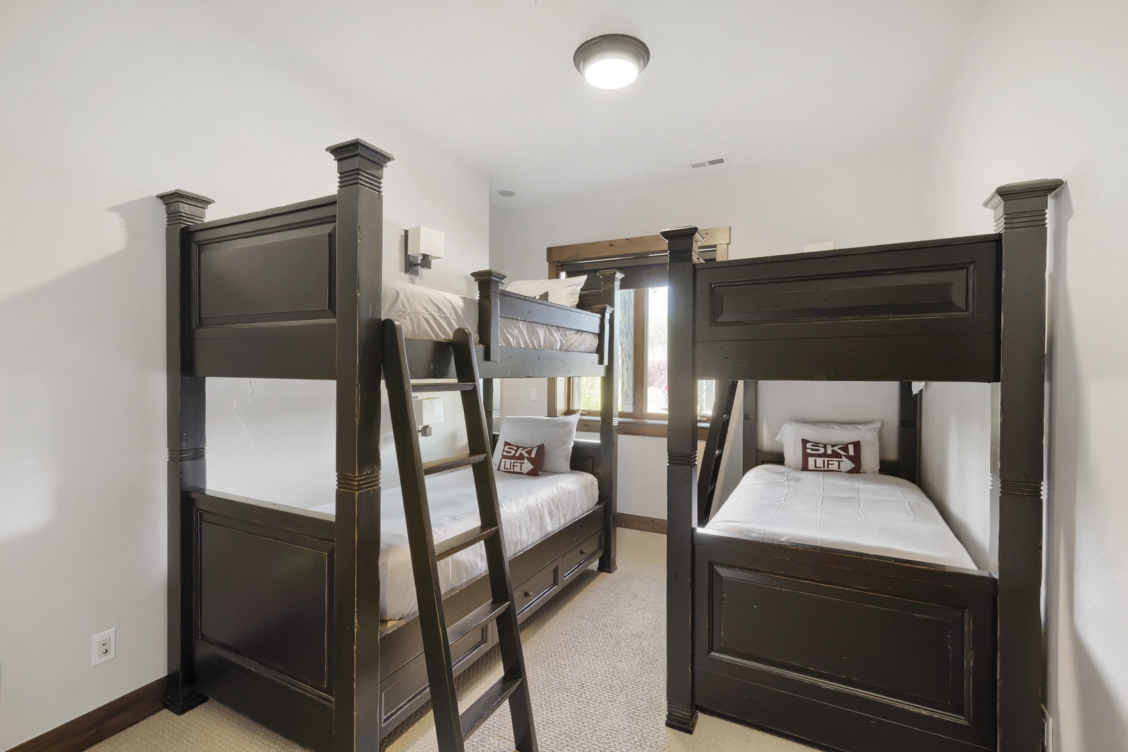 Two sturdy bunk beds create a cozy retreat where your group can rest after a day of adventure. Clean white linens and thoughtful storage drawers offer comfort and convenience for everyone.