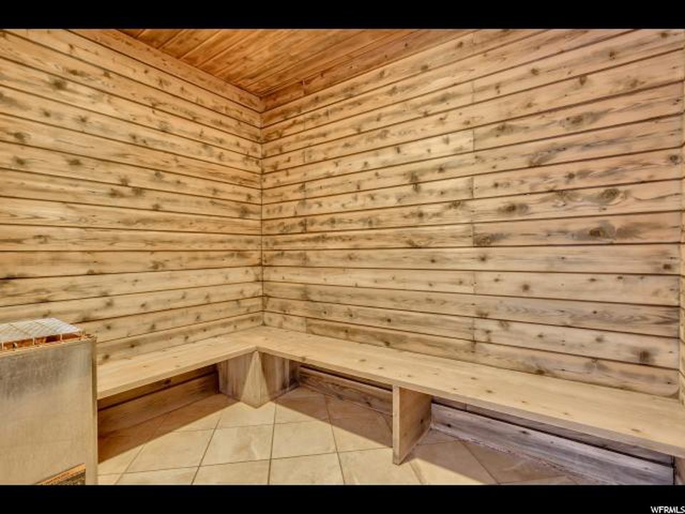 Wood-paneled sauna room with built-in bench seating and a tiled floor.