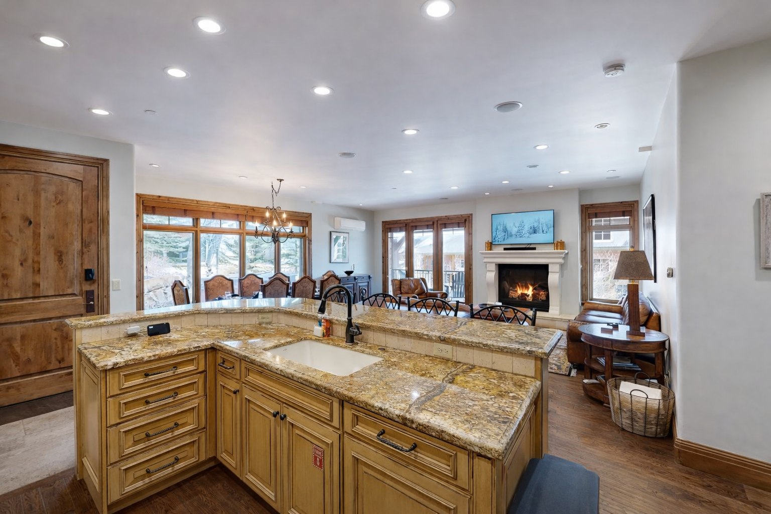 Prepare gourmet meals in this elegant, traditional kitchen. Featuring light wood cabinetry, a grand range hood, and a sprawling granite island, it's a chef's dream with high-end appliances.