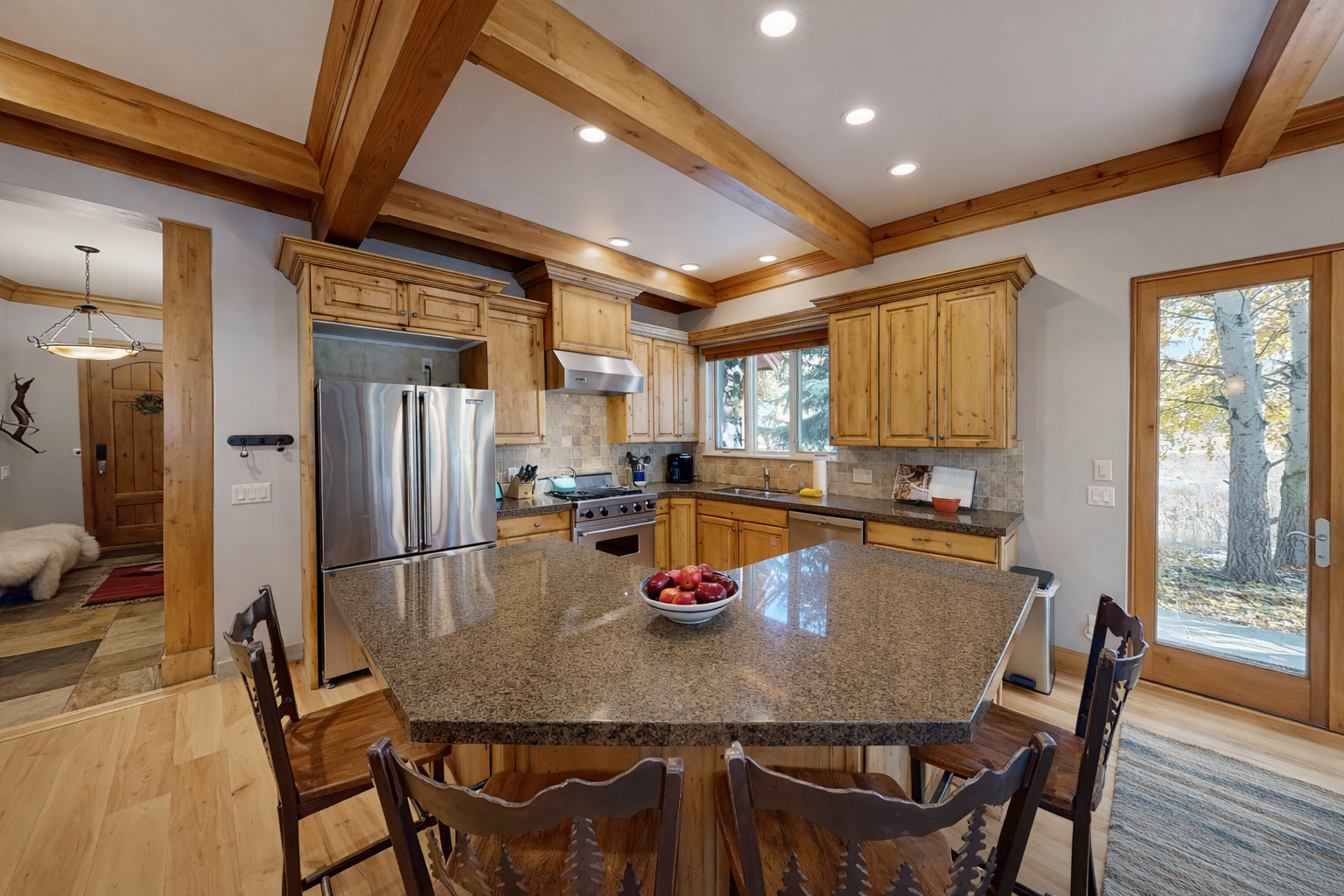 Cook in a gourmet rustic kitchen! Featuring stunning granite countertops, high-end stainless steel appliances, custom knotty-wood cabinetry, and unique bear-themed bar stools.