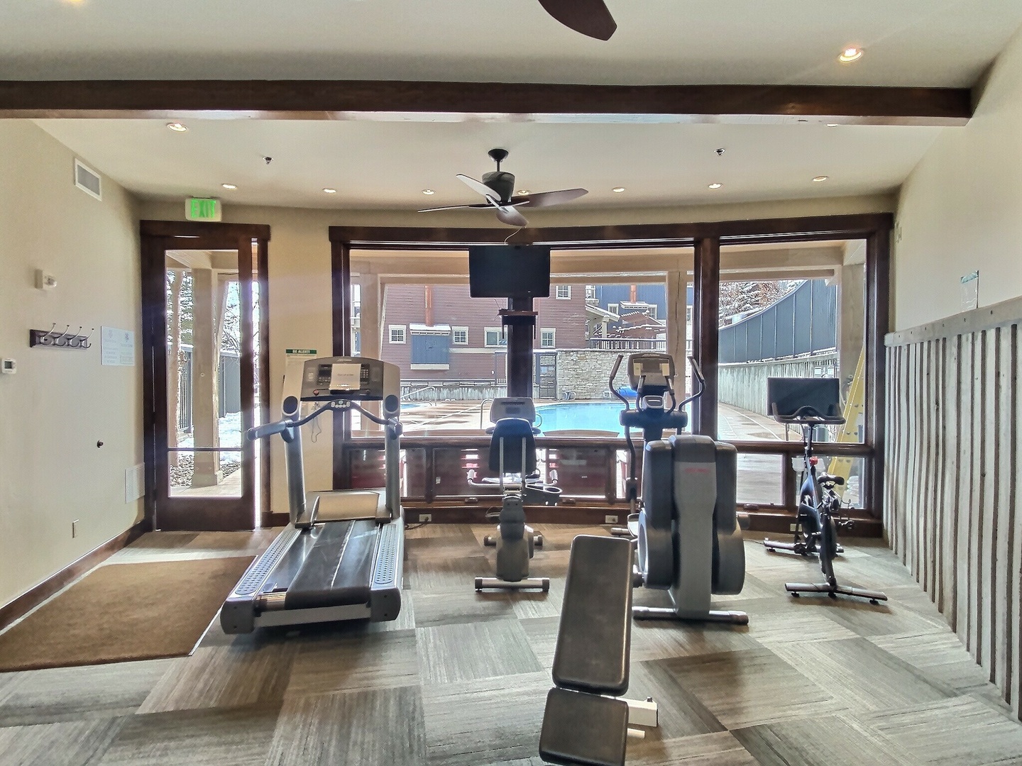 Stay fit and energized in your private workout space, complete with cardio and strength equipment, ceiling fans for comfort, and inspiring views of the pool deck just beyond the glass doors.