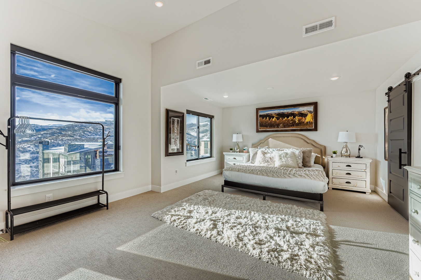 Wake up to stunning mountain vistas from your serene bedroom retreat. The plush bed and soft textures invite you to unwind in comfort, while expansive windows frame breathtaking views that make every morning memorable.