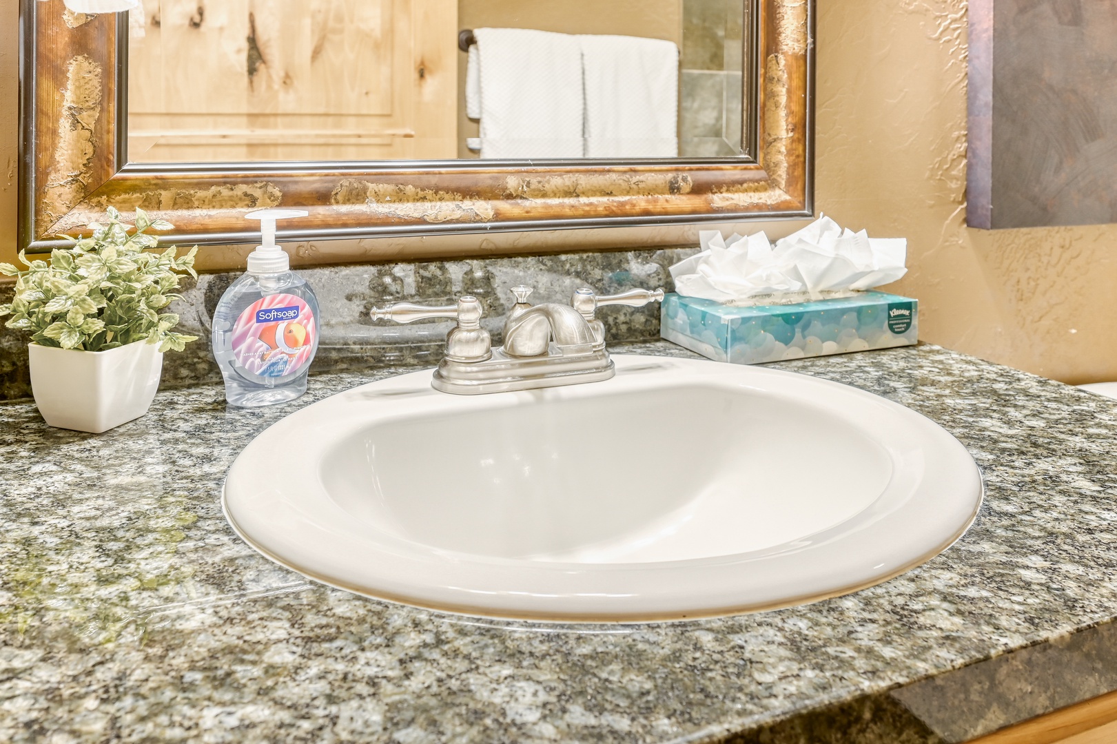 Unwind in your private bathroom featuring granite counters, rustic wood cabinetry, and a relaxing tub-shower combo with elegant tile work.