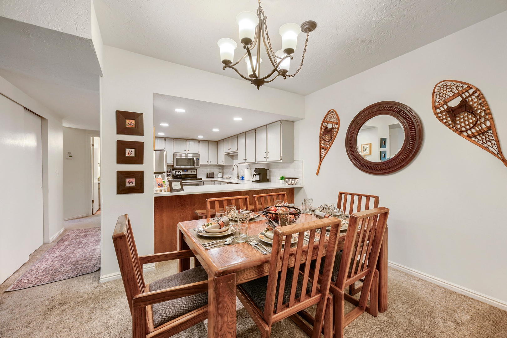 Gather around a beautifully set dining table with seating for your whole group. The open layout flows into a bright, fully-equipped kitchen where you can share meals and make memories together.