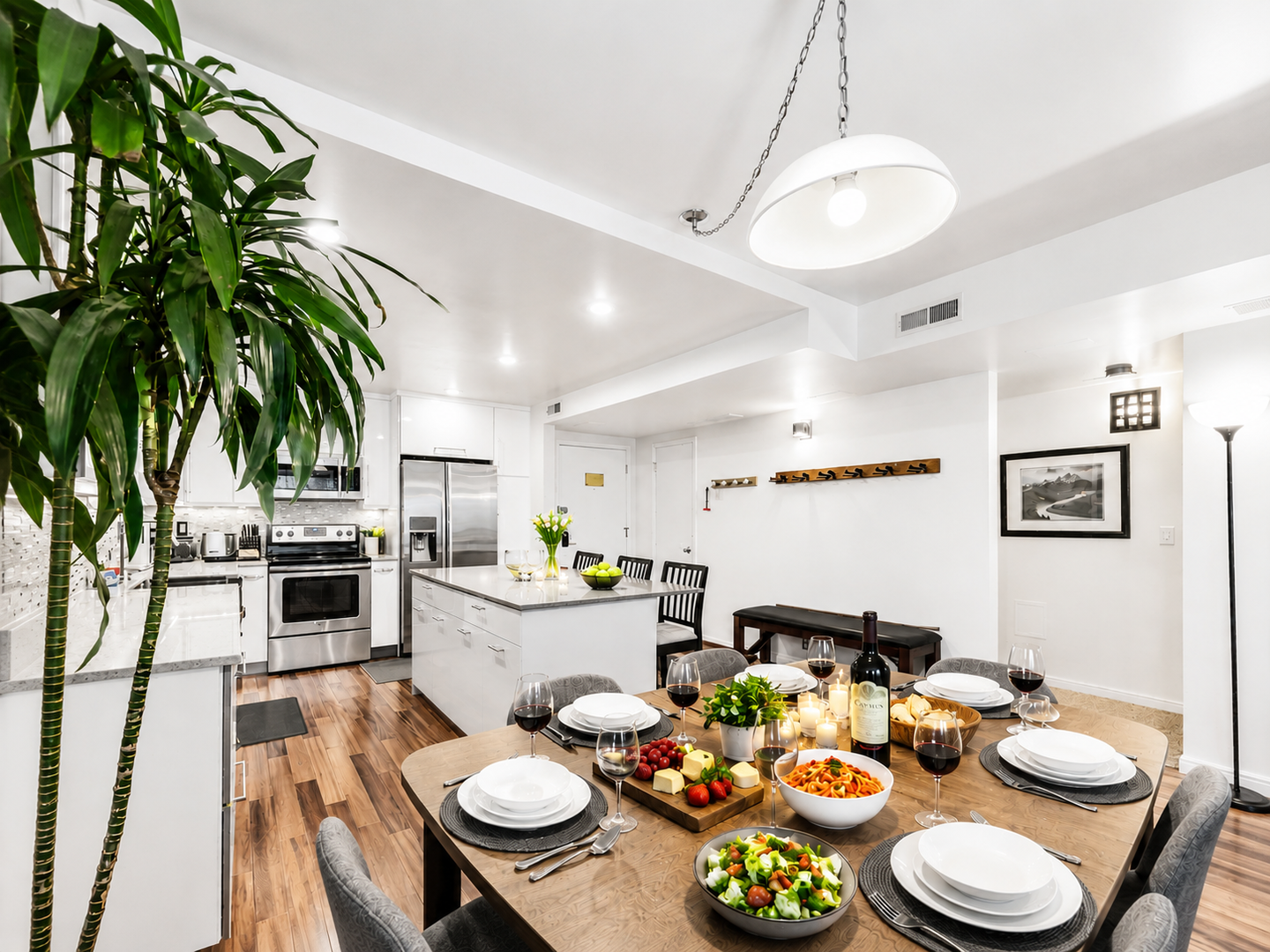 Dine and entertain in our open-concept living space, featuring a modern kitchen with stainless steel appliances and a large dining table. The perfect spot to relax and share meals.