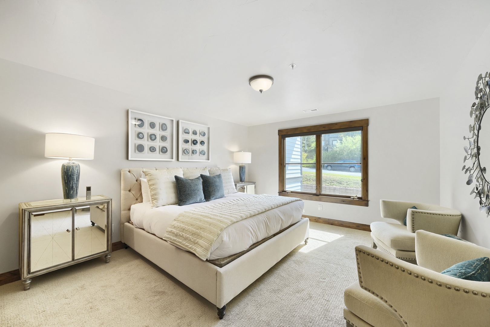Sink into your plush bed and let natural light pour through the window, where soft neutrals and elegant furnishings create a serene retreat just for you.