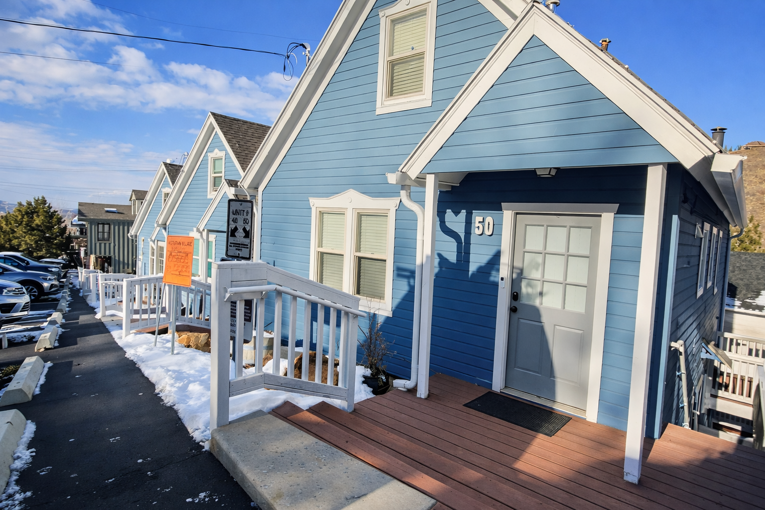 Charming blue cottage with white trim and welcoming front porch, clearly marked as unit 50.