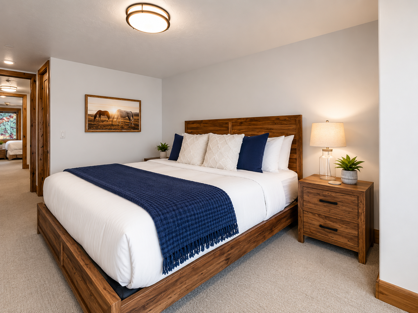 This serene guest bedroom features a plush king bed with crisp linens and a stylish blue throw. Large wood-trimmed windows offer stunning mountain views from your pillow.
