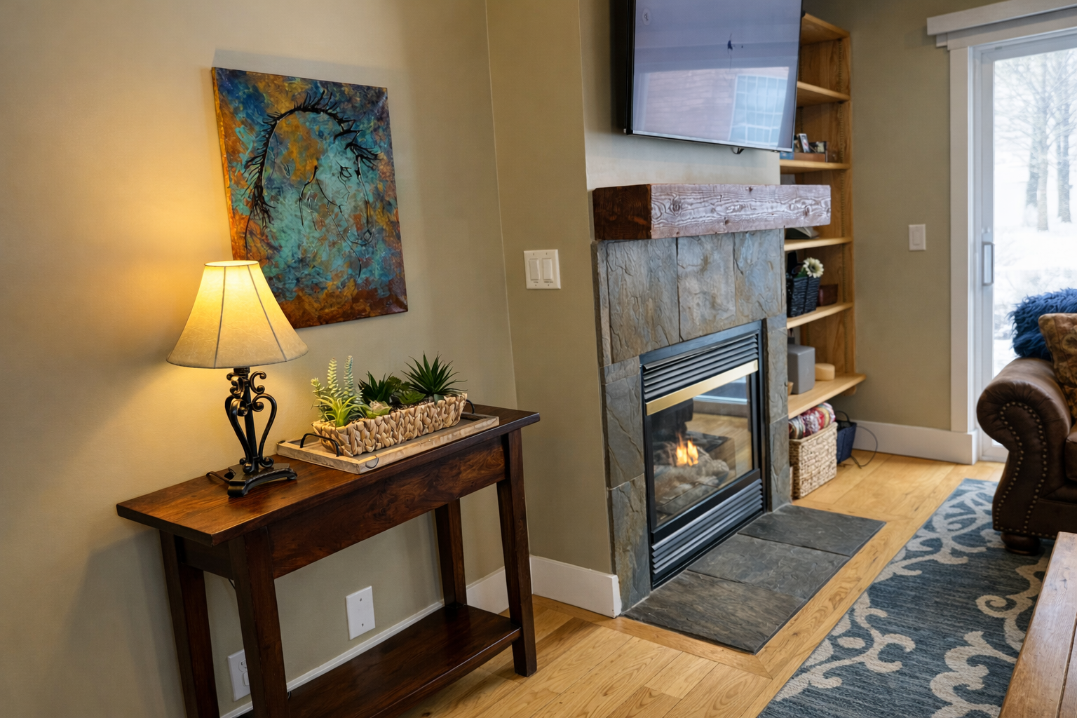 Relax in this cozy mountain retreat featuring a warm fireplace, rustic wooden accents, and plush seating. Enjoy modern amenities like a wall-mounted TV and large windows with bright, natural light.