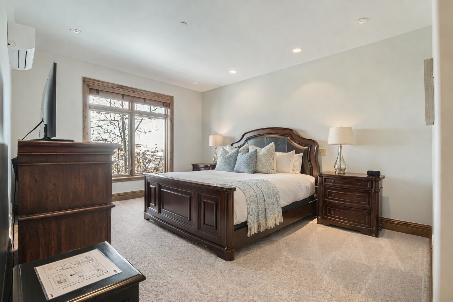 Sink into your elegant master suite with rich wood furnishings and soft lighting for peaceful nights.