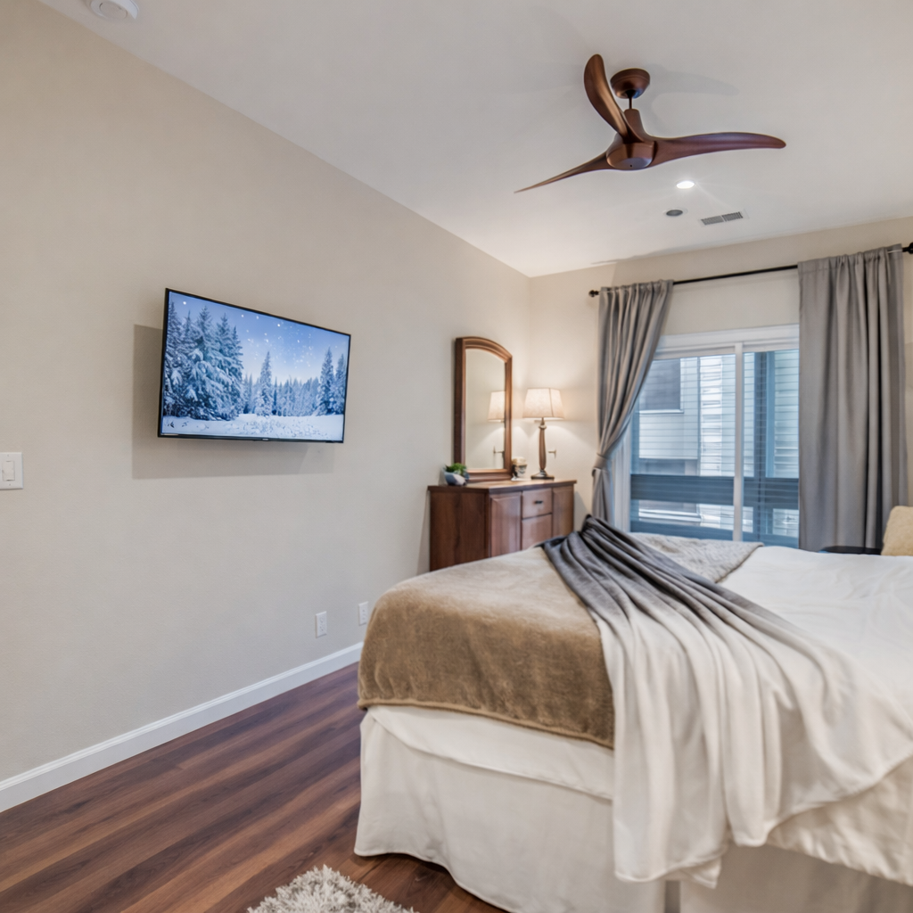 Unwind in your stylish bedroom with premium linens, modern TV, and city views through elegant curtains.