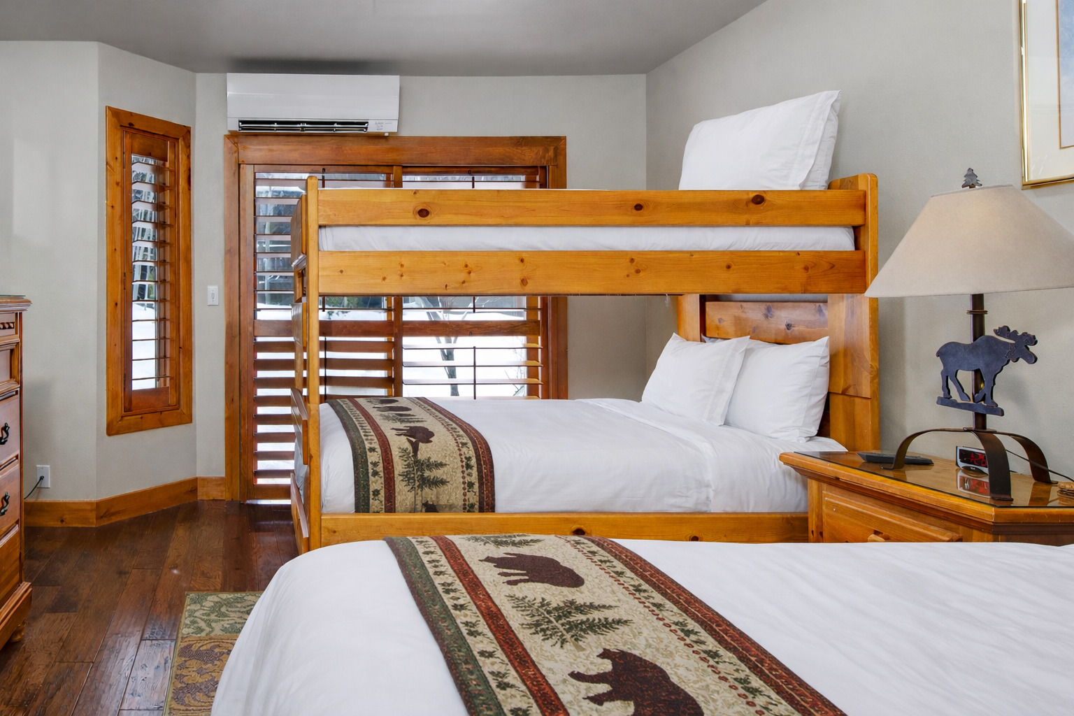 Your cozy bunk room features rustic wood furnishings and mountain-themed art, perfect for family adventures or friend getaways.