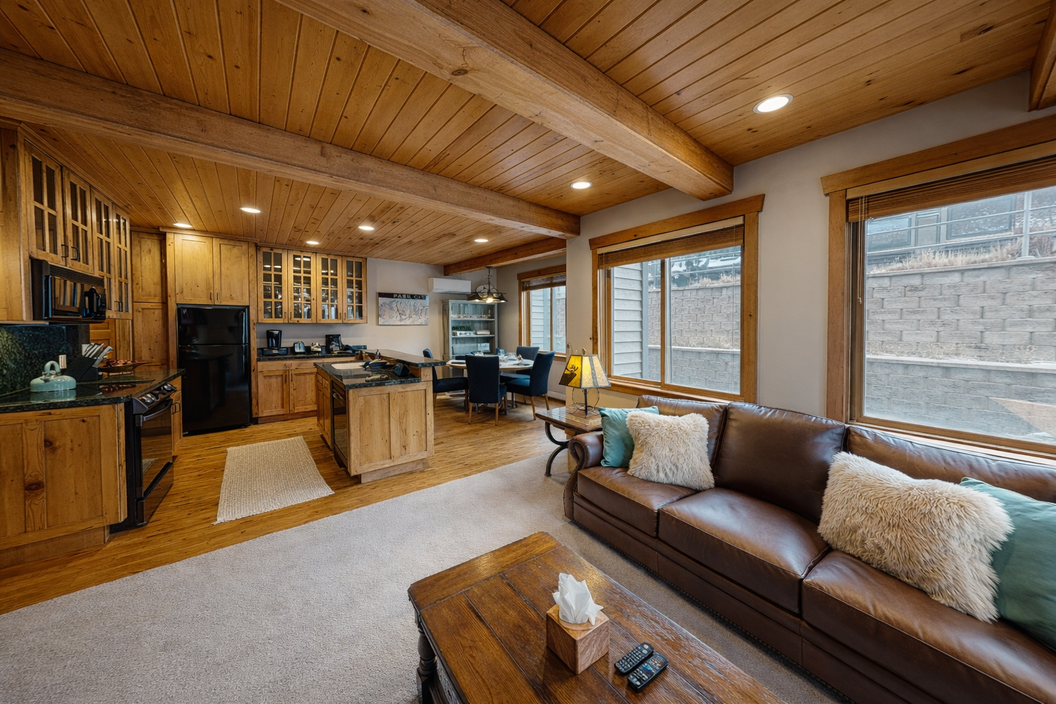 Sink into your plush sectional sofa while the fireplace crackles and natural light streams through wooden blinds in this cozy mountain retreat.