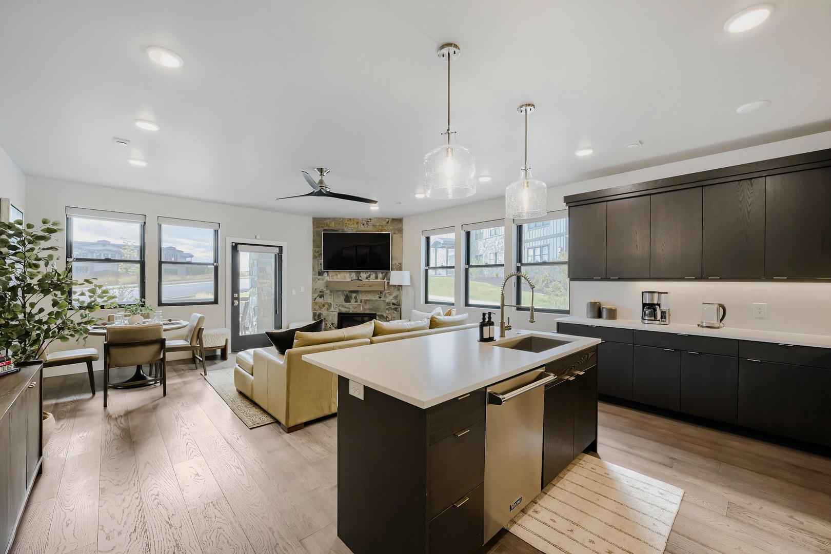 Your open-concept living space combines a sleek kitchen, cozy lounge, and dining area with abundant natural light and modern finishes. Relax by the fireplace or gather around the island.