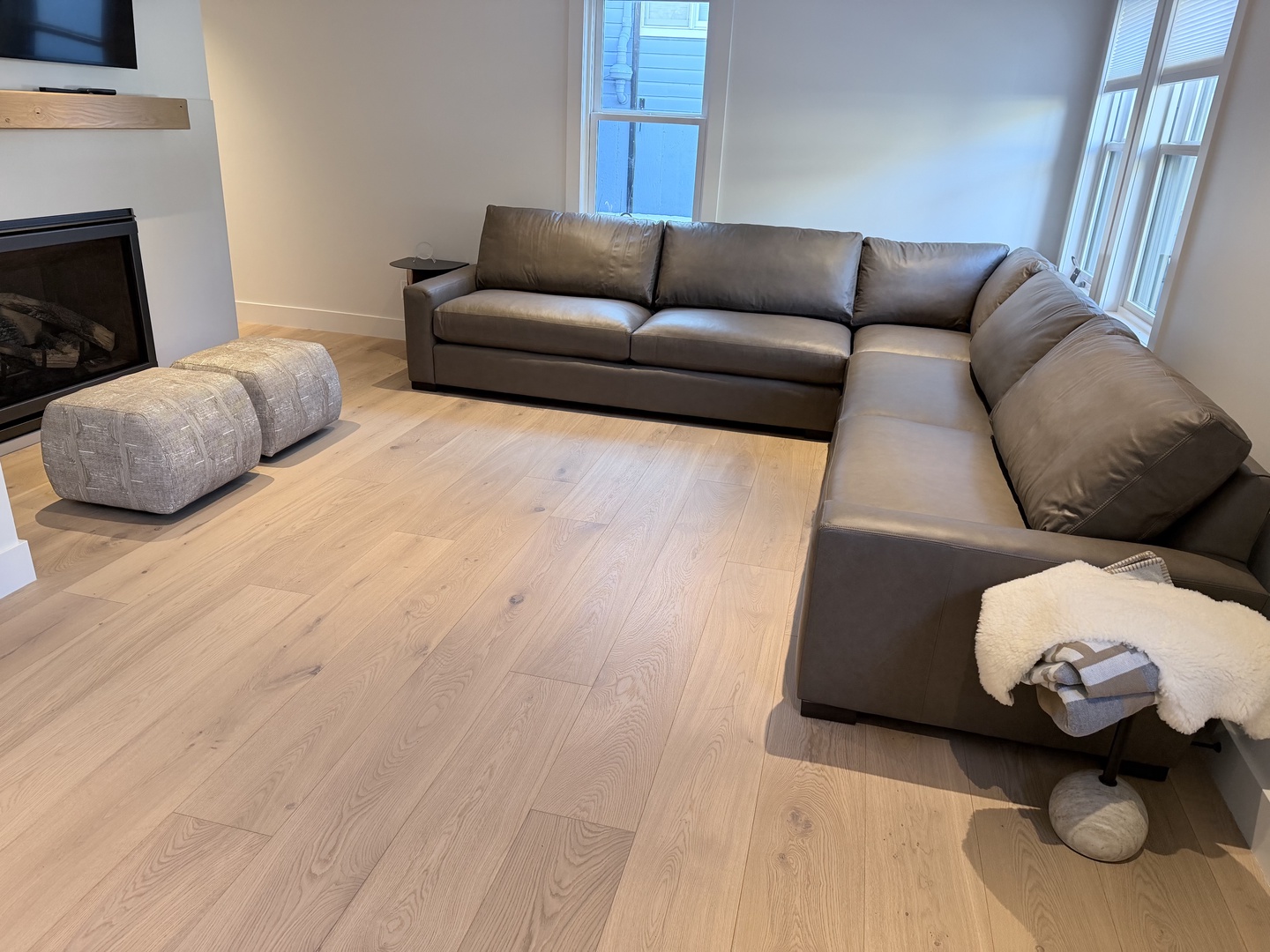 Settle into your spacious living room with a plush sectional sofa and cozy fireplace, perfect for relaxing after exploring the area.