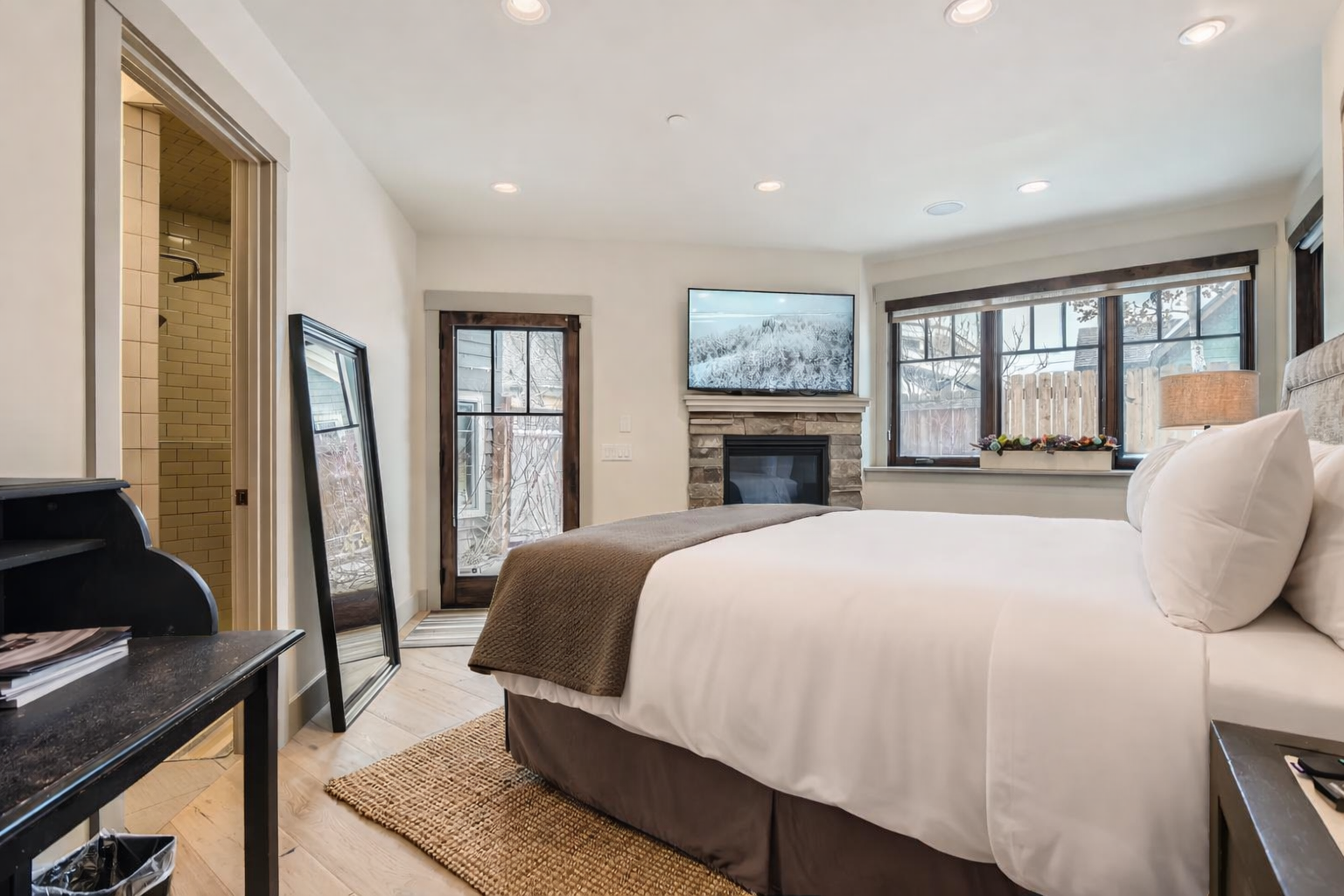 Retreat to the stylish master suite featuring a large king-size bed, a cozy fireplace, and a dedicated TV for relaxing after exploring Park City.
