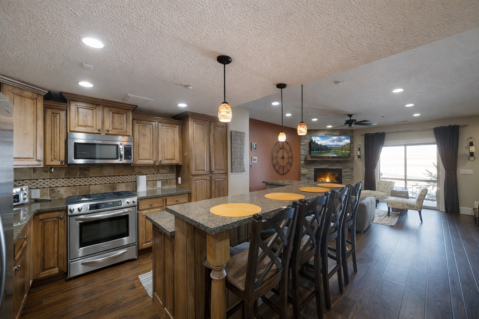 Prepare a gourmet meal in this warm, inviting kitchen featuring rich wood cabinetry and a spacious breakfast bar with seating for four.