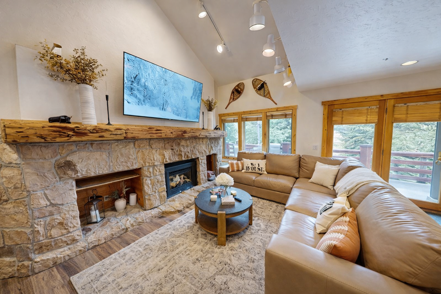Sink into plush leather seating by your stone fireplace, where rustic charm meets modern comfort in this inviting living space.