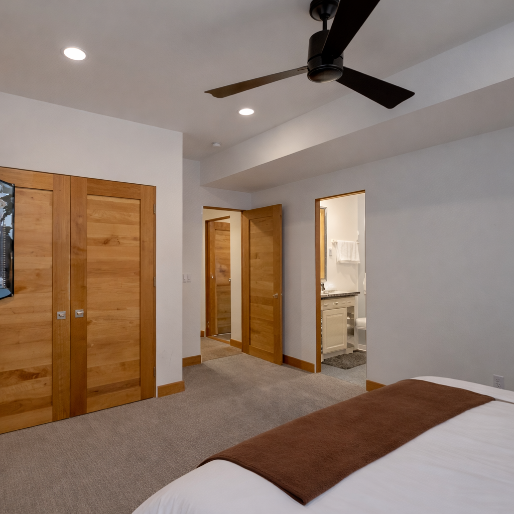 Retire to this quiet, second floor king bedroom. Features a comfortable king bed, modern ceiling fan, and ample closet space with wood doors. The perfect escape after a busy day.