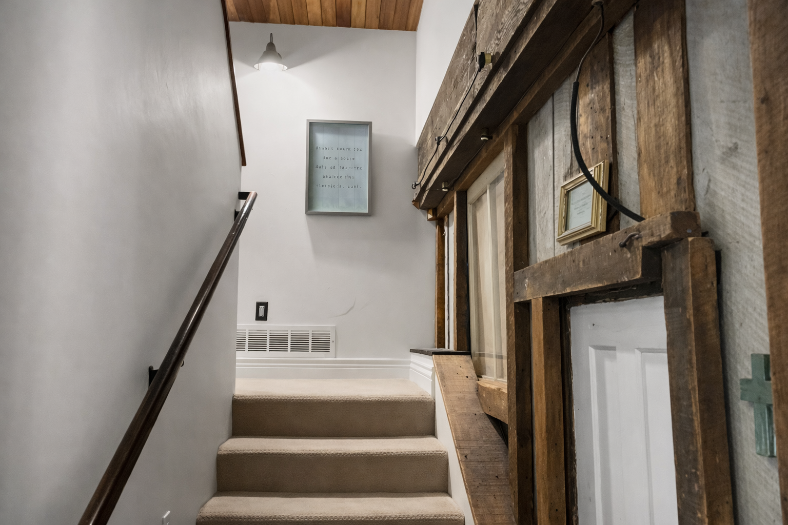 Step into your historic retreat where exposed wooden beams and modern comfort blend seamlessly, creating an inviting stairway to your upstairs sanctuary.