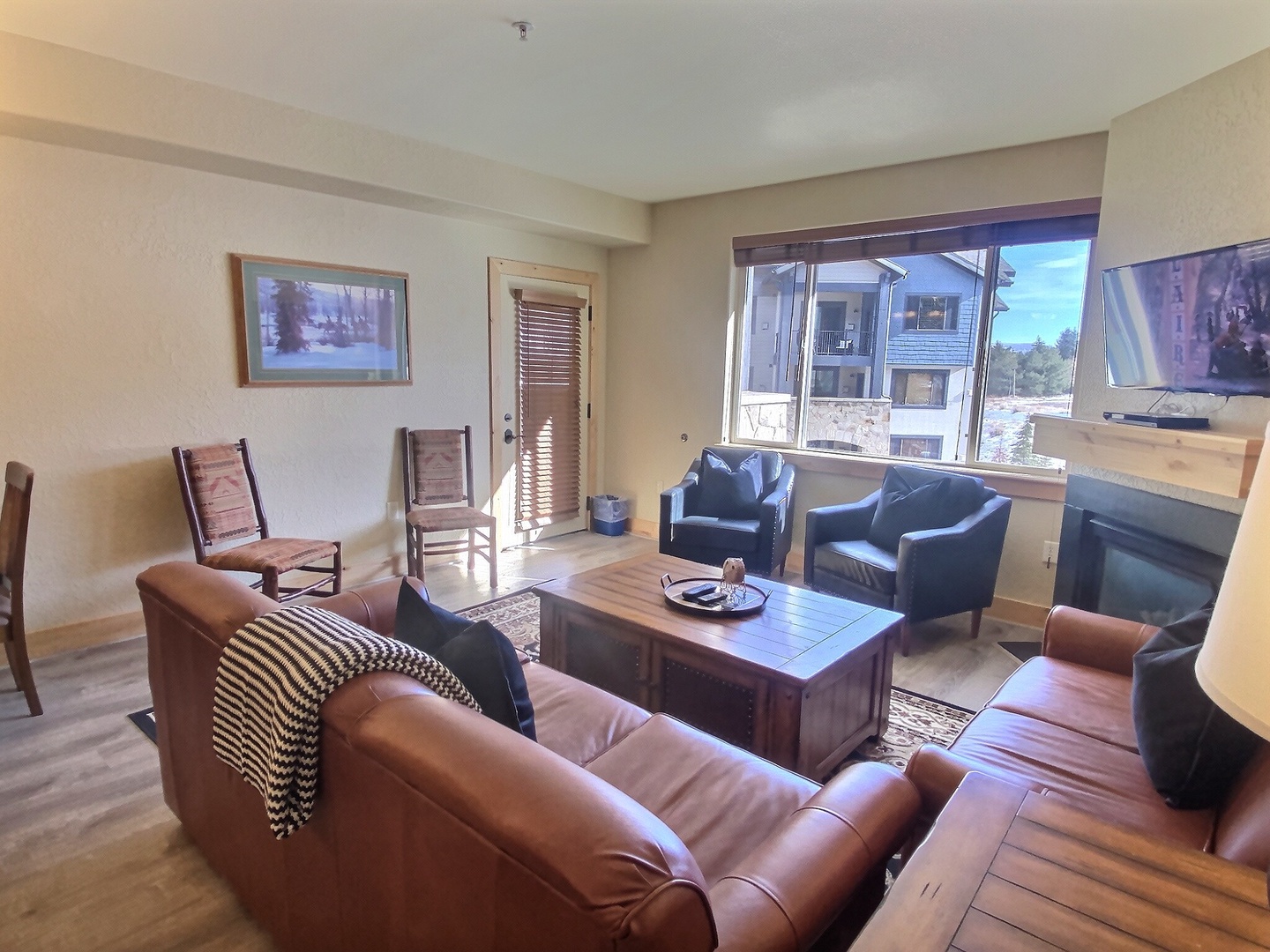 Settle into your spacious living room with leather seating, a fireplace to warm your evenings, and windows framing mountain views. Perfect for gathering after a day of adventure.