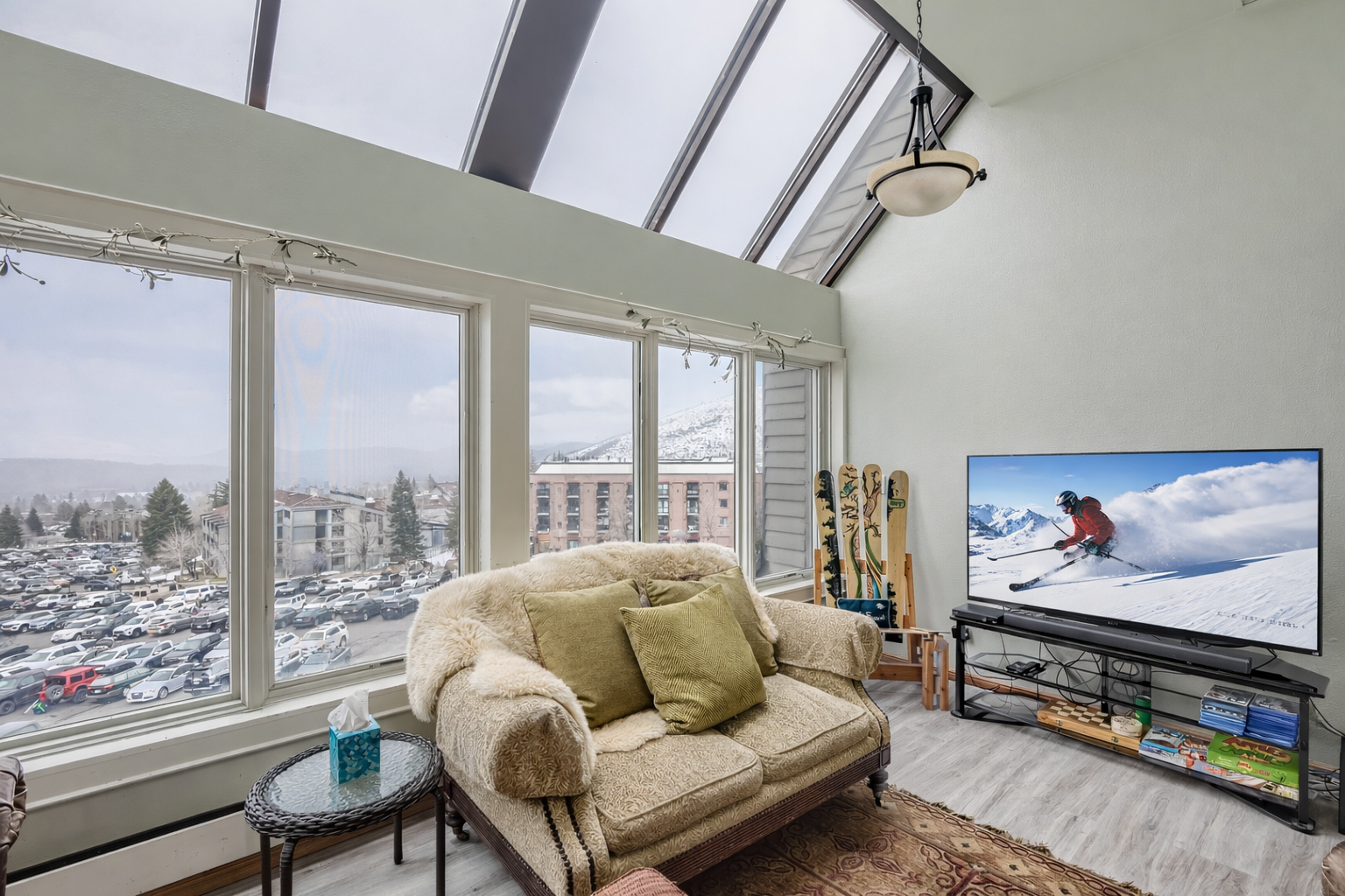 Bright, open-concept living area with large windows, scenic views, skylights, and cozy seating. The perfect mountain basecamp.