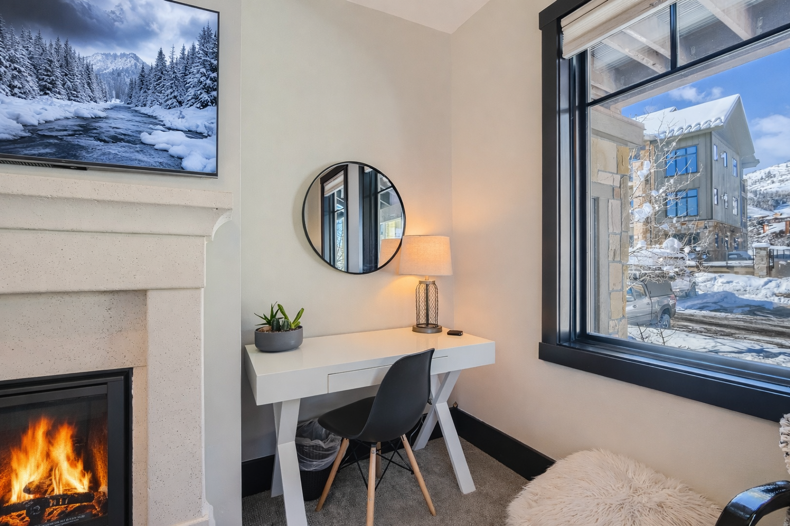 Cozy up in your private corner workspace, where crackling flames and snowy mountain views create the perfect retreat for productivity.