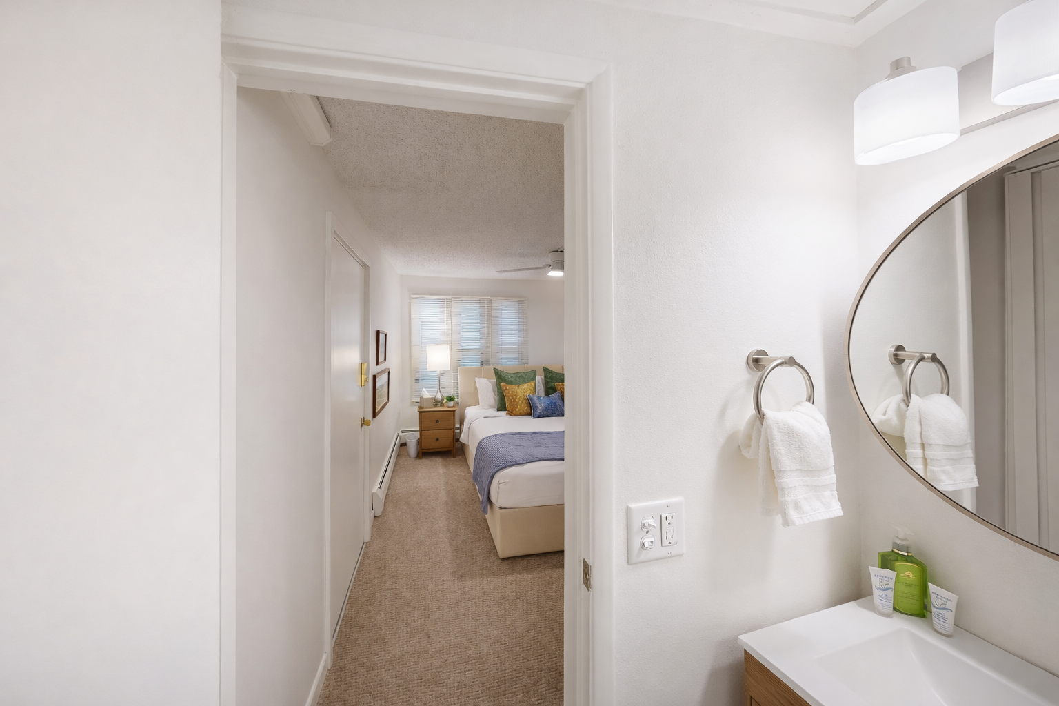 Step into your bright, modern bathroom with fresh towels and premium amenities, perfectly positioned near your comfortable bedroom retreat.