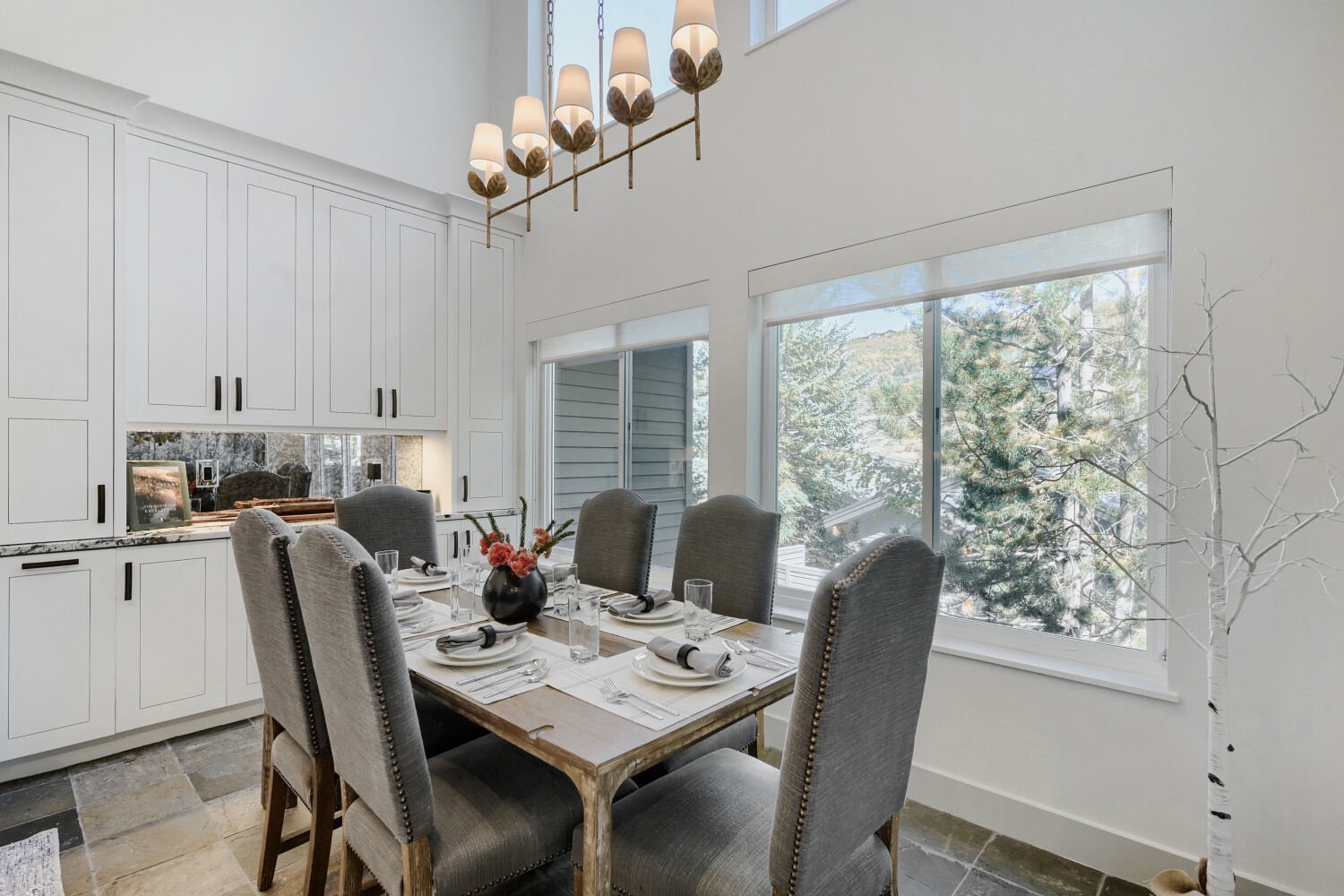 Gather around the elegantly set dining table for memorable meals, with natural light streaming through large windows and built-in cabinetry adding warmth and charm.