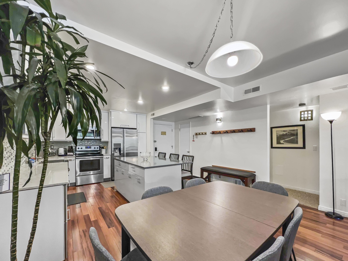 Step into your open-concept kitchen and dining area, where sleek appliances and warm hardwood floors invite you to gather around the table. The bright, airy space feels modern and welcoming.