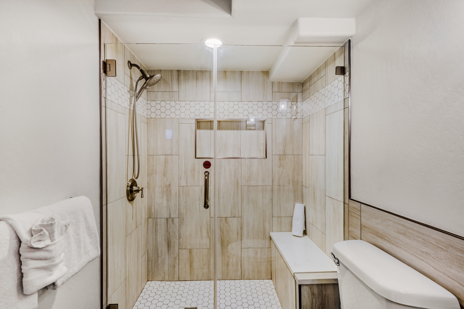 Step into your private spa-like shower with elegant wood-look tile, rainfall head, and built-in seating for pure relaxation.