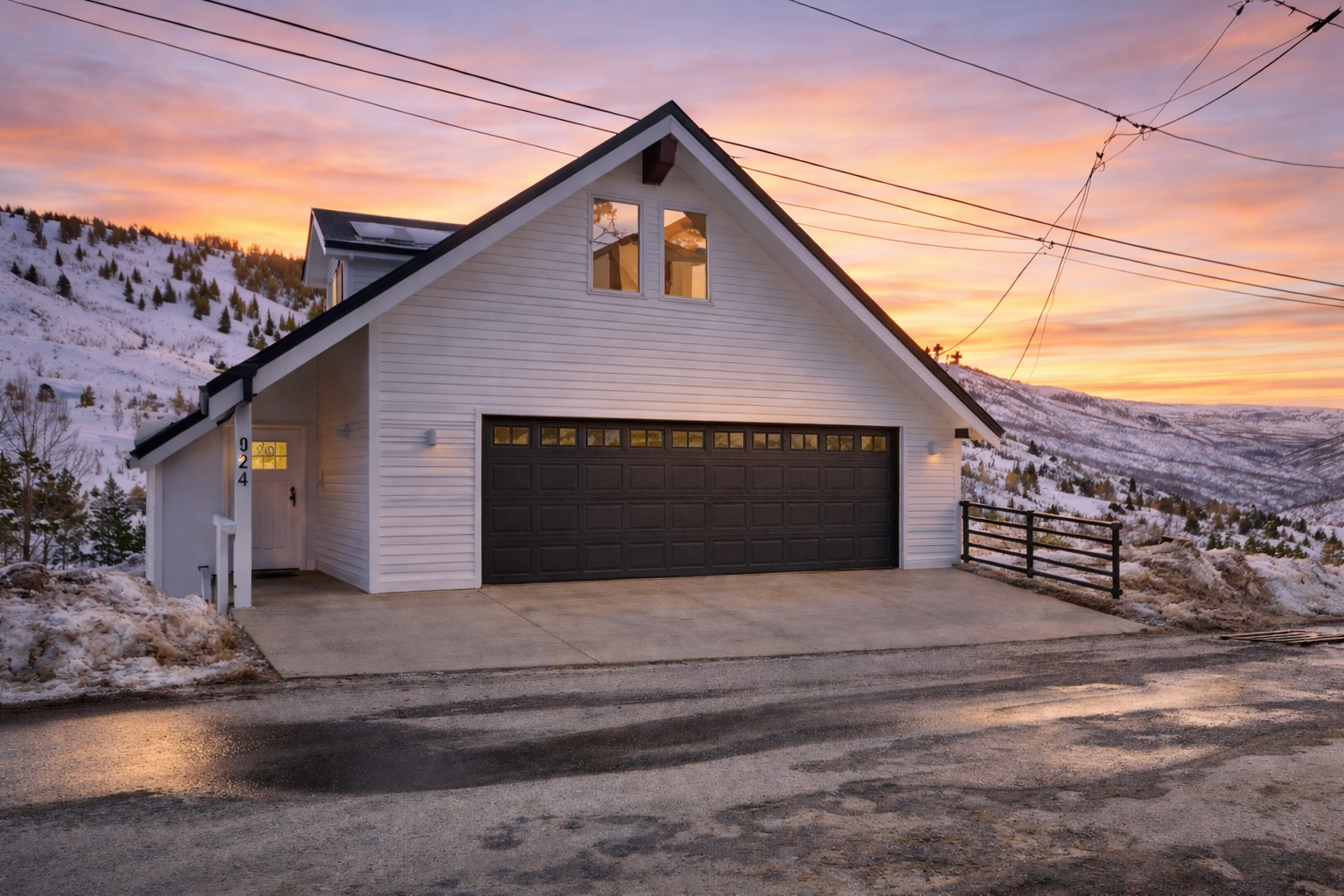 Mountain home with stunning winter landscape surroundings and vibrant sunset backdrop creates a picturesque arrival experience.