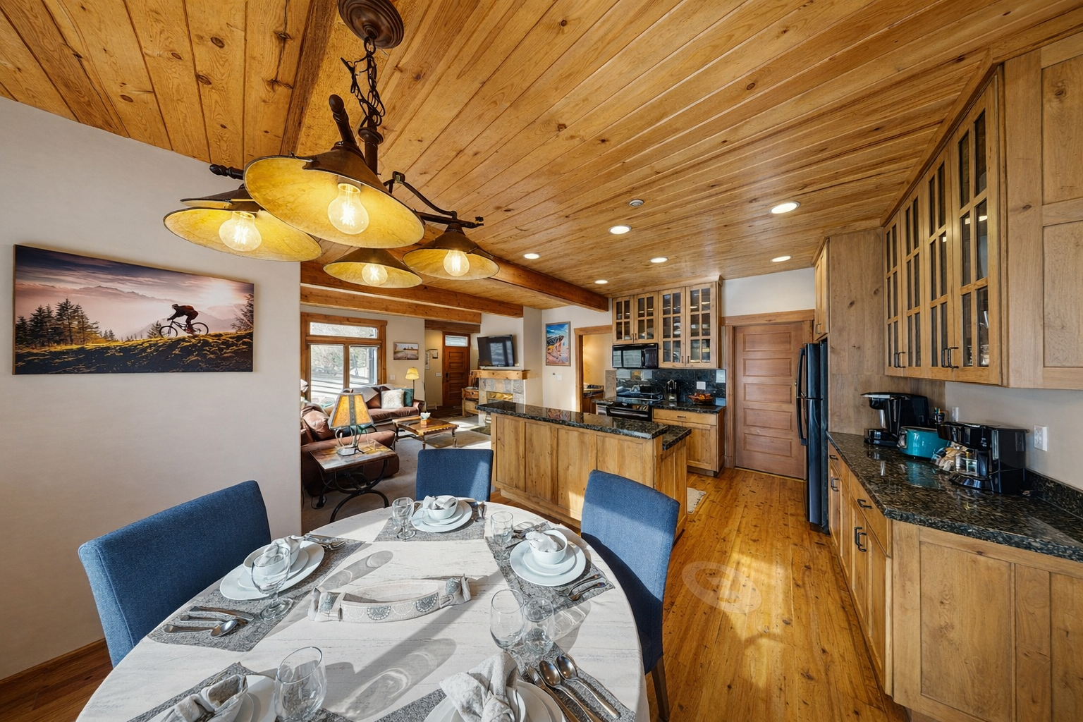 Gather for memorable meals around the cozy dining table beneath the rustic wagon wheel chandelier. The fully equipped kitchen is steps away.