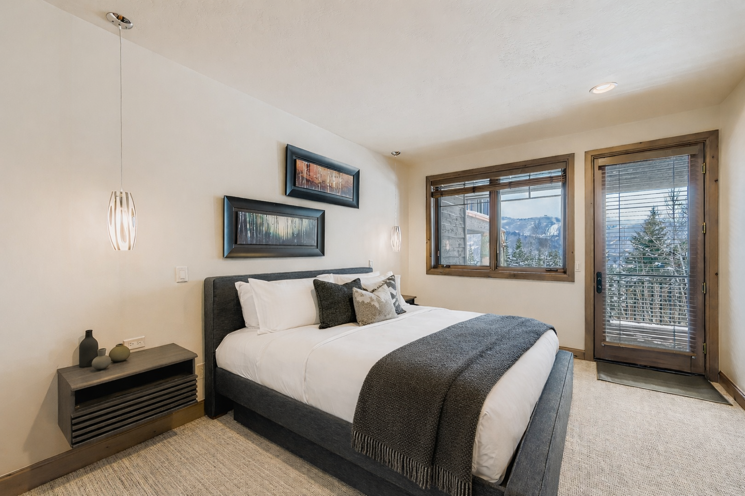 Wake up to mountain views in your serene bedroom, where modern comfort meets natural beauty through expansive windows and private balcony access.
