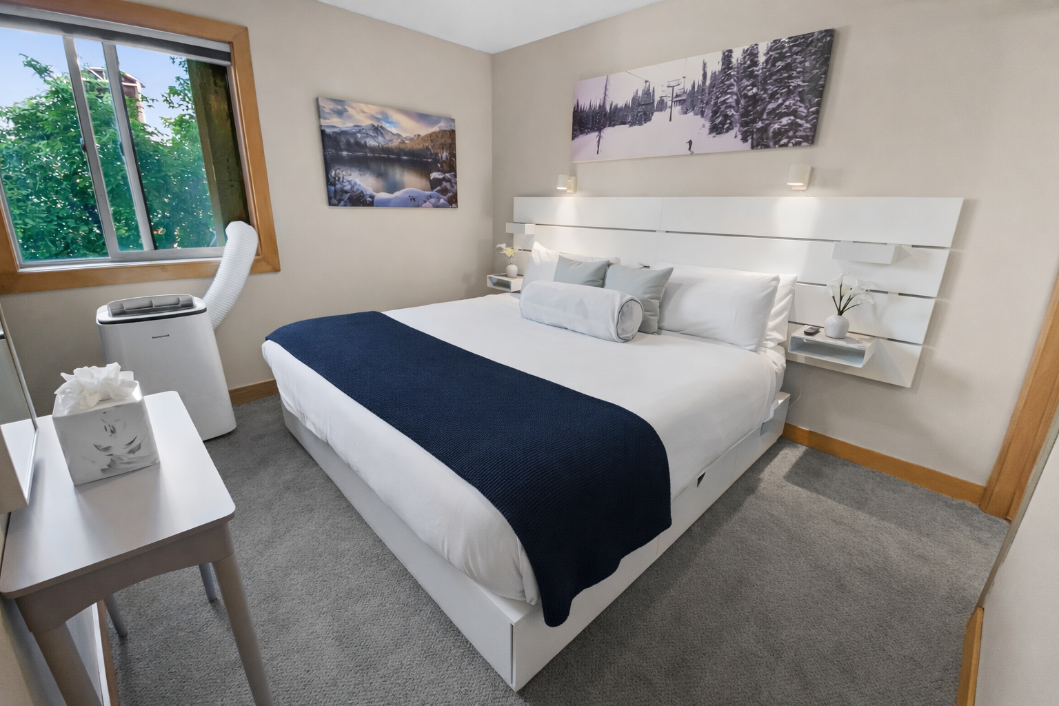 Modern & serene primary bedroom with a plush king bed and stylish mountain art.