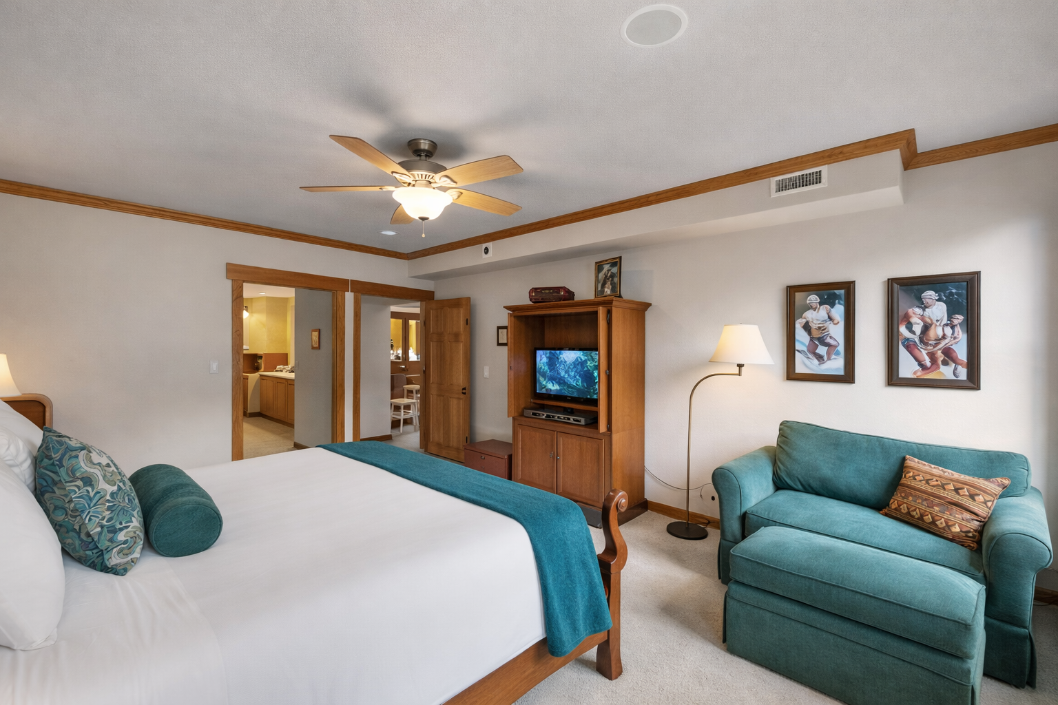 Inviting primary bedroom featuring a comfortable king-size bed, cozy seating area, ceiling fan, and ample natural light. A tranquil retreat for a restful stay in the mountains.