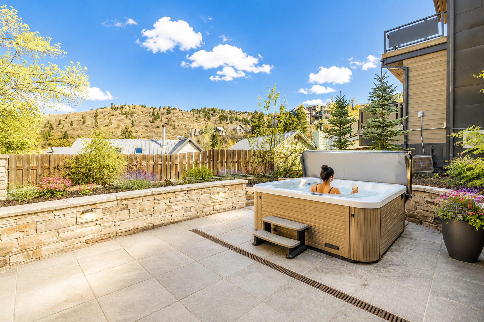 Soak away your cares in your private hot tub, surrounded by vibrant blooms and stunning mountain views that stretch endlessly beyond the peaceful patio.