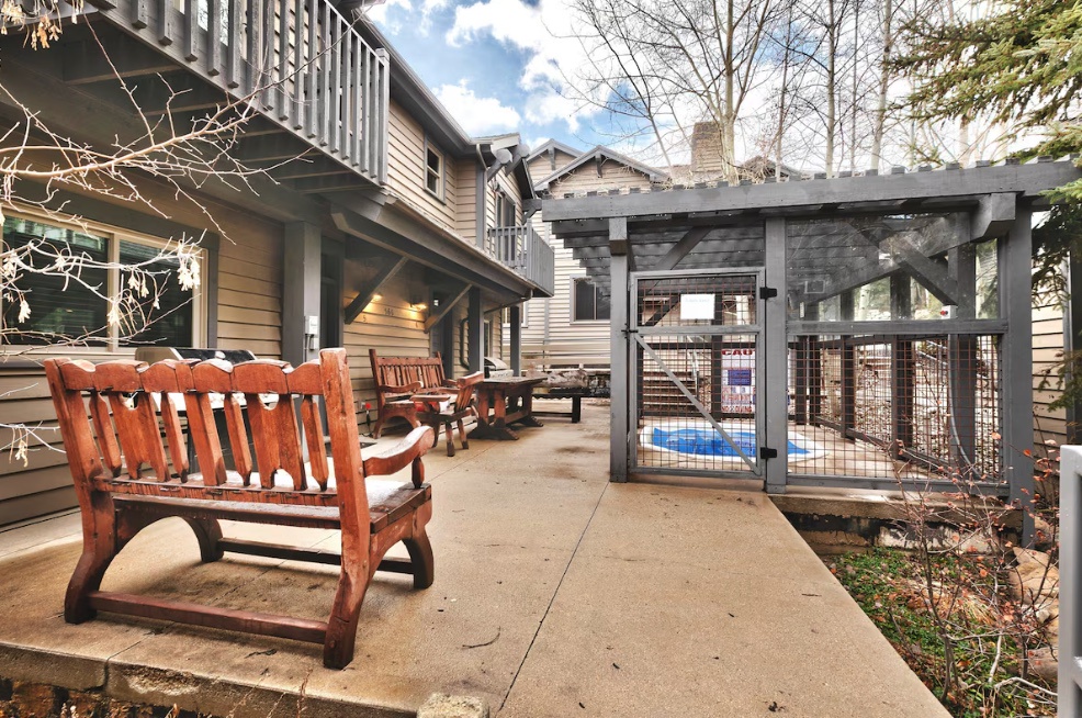 Relax on the community patio with rustic wooden benches and peaceful outdoor seating areas perfect for morning coffee or evening conversations.