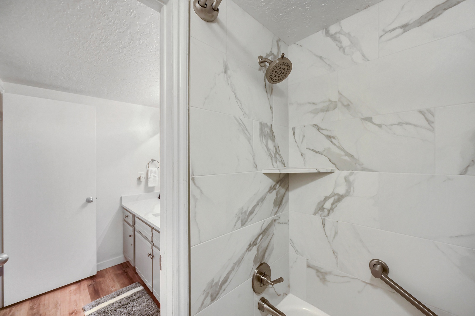 Step into your elegant marble-tiled shower with modern fixtures. The clean design and spa-like ambiance create a refreshing retreat after a day of exploring.