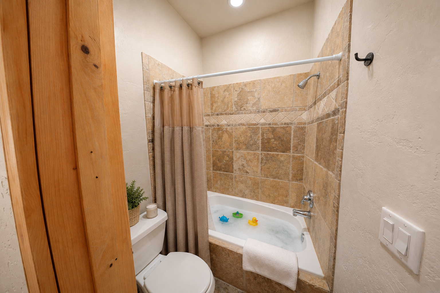 Step into your private bathroom where warm tile and a soothing tub invite you to unwind after a day of adventure. The soft lighting and cozy design make it the perfect spot for your evening wind-down.