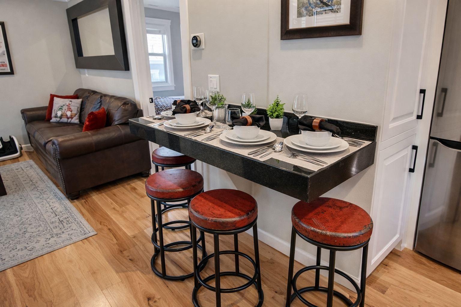 Enjoy intimate meals at your elegant breakfast bar with wine glasses ready for dining, while relaxing on the cozy leather sofa nearby.