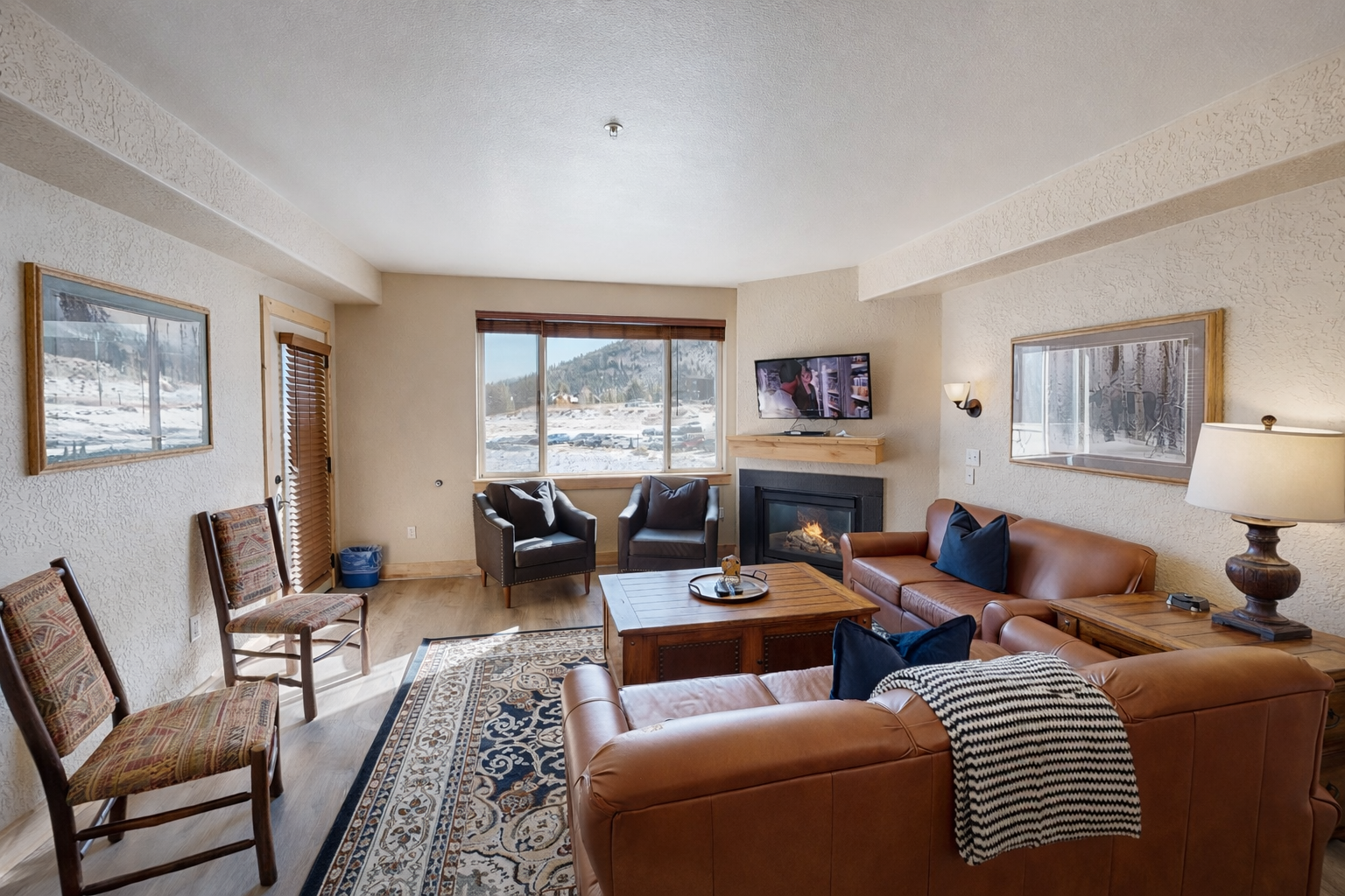Unwind in this sun-drenched mountain retreat featuring a cozy fireplace, plush leather seating, and large windows. Perfect for relaxing after a day of adventure with stunning alpine views.