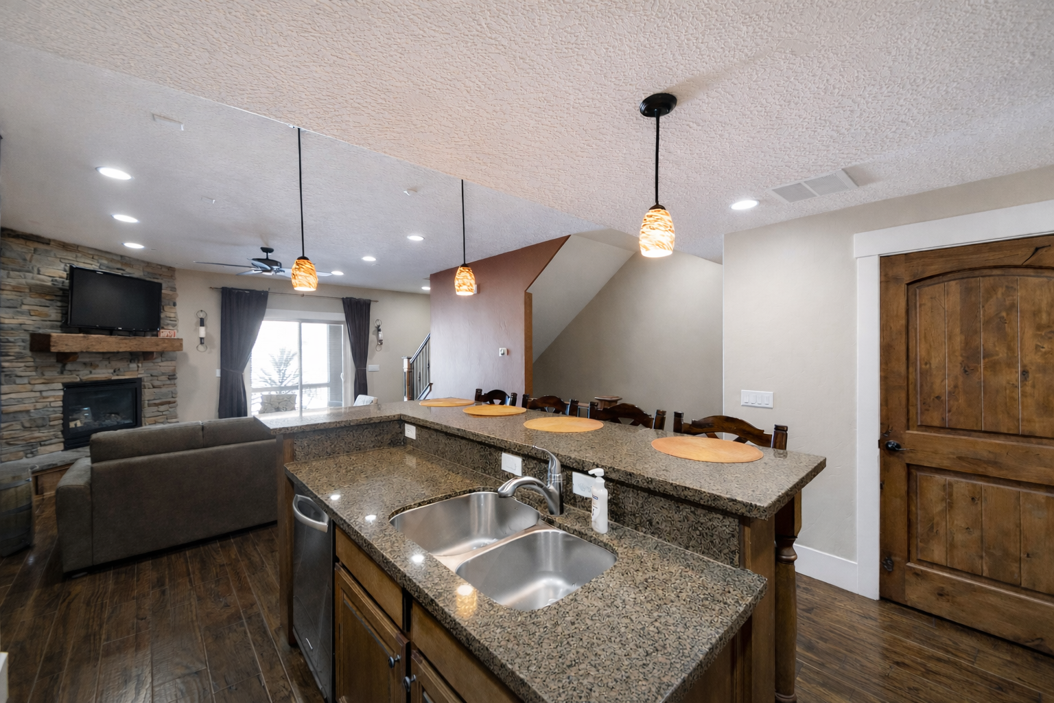 Prepare a gourmet meal in this warm, inviting kitchen featuring rich wood cabinetry and a spacious breakfast bar with seating for four.