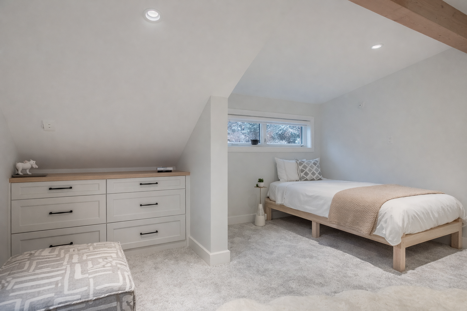 Relax in your bright loft bedroom with sloped ceilings, cozy bedding, and ample storage to keep your belongings organized.