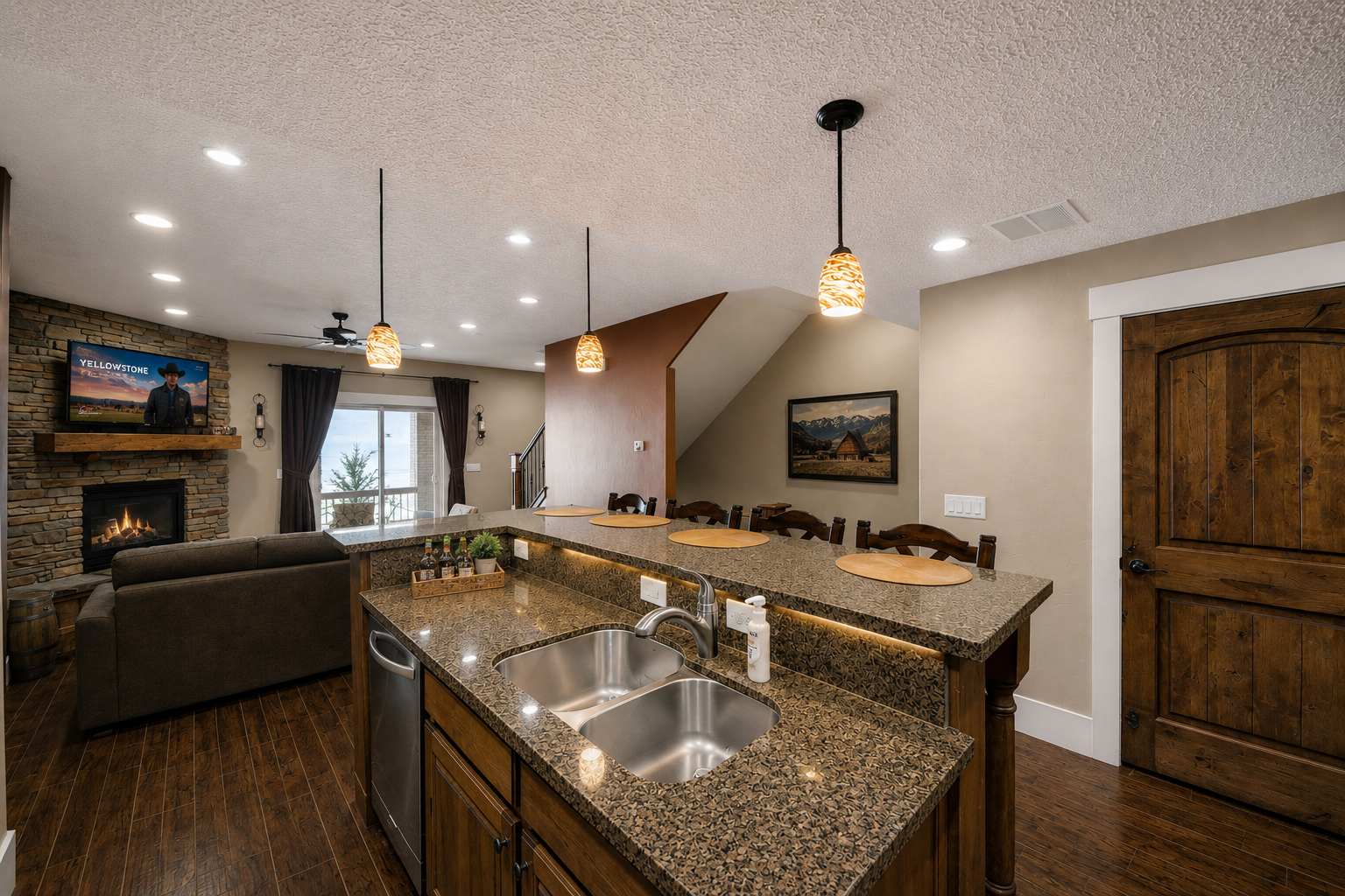 Gather around the spacious kitchen island with stunning granite countertops, where your group can cook, chat, and enjoy the cozy fireplace glow from the open living area—all under the warmth of stylish pendant lighting.