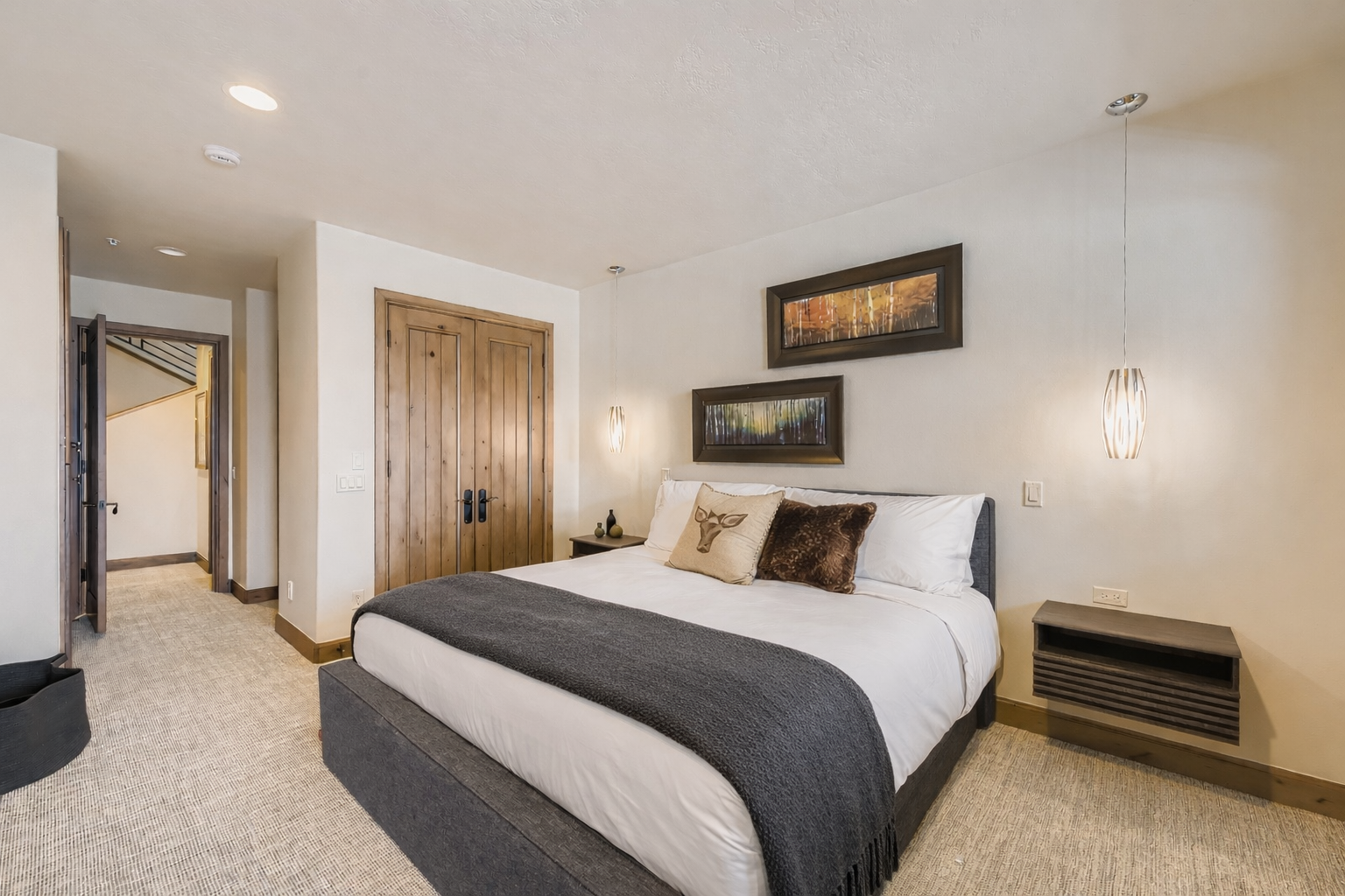 Drift into peaceful slumber in your elegantly appointed bedroom, where crisp linens and thoughtful artwork create a serene mountain retreat atmosphere.