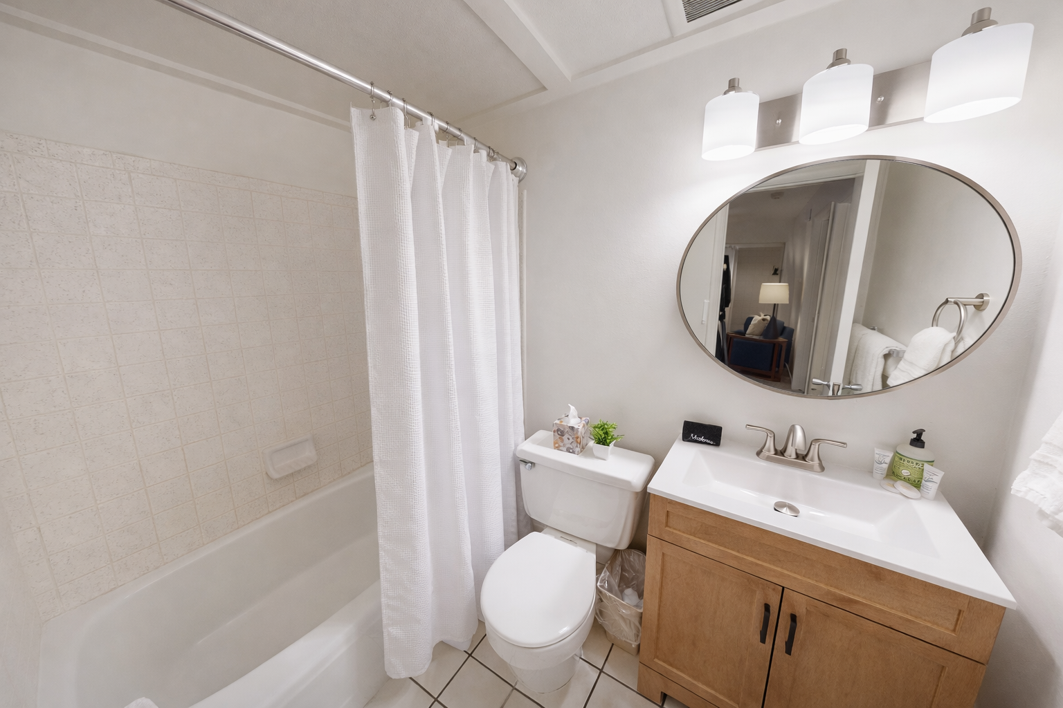 Modern & clean full bathroom featuring a sleek tub/shower combo and a stylish vanity. A refreshing space to unwind during your stay.