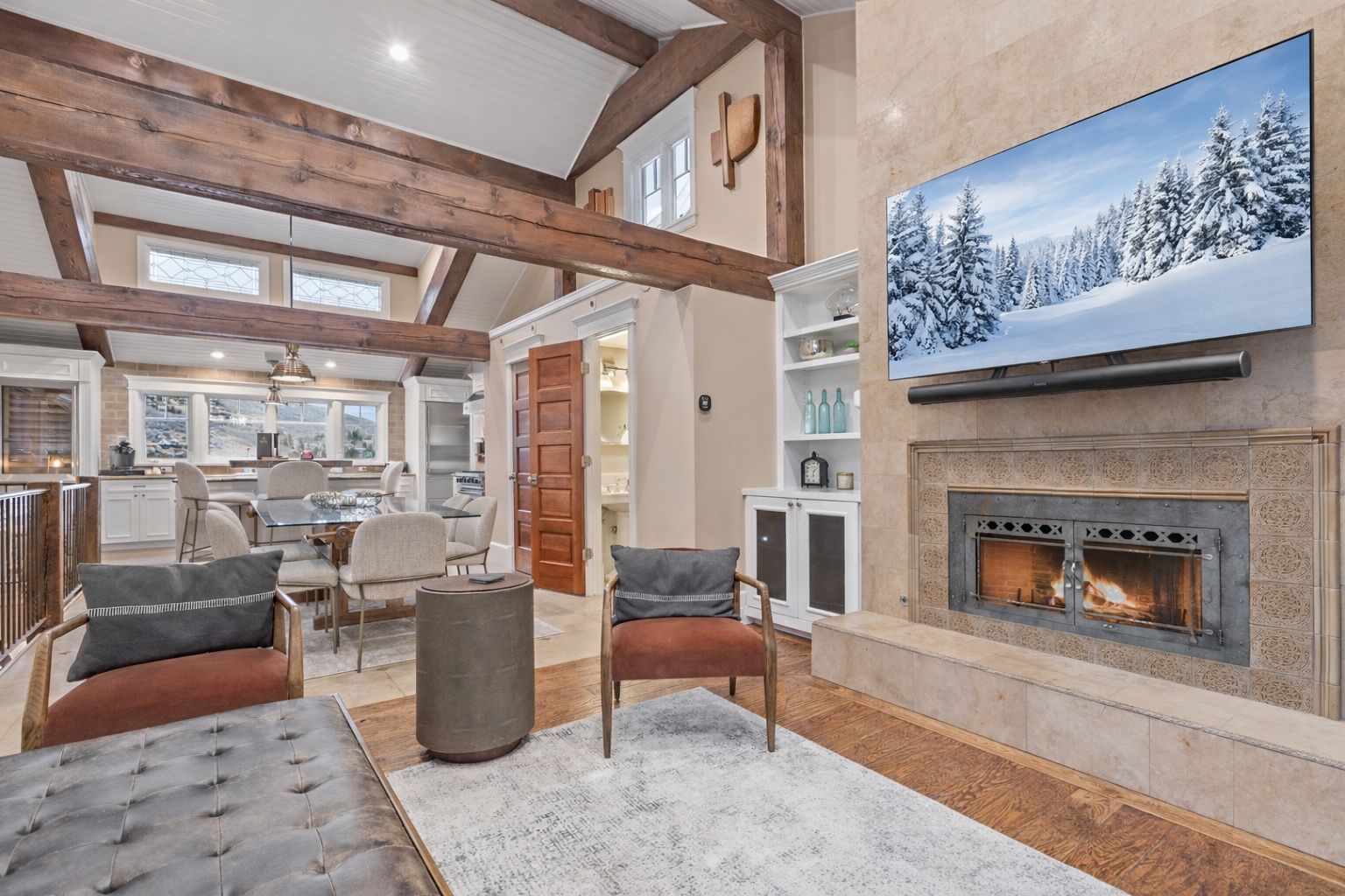 Gather around your cozy fireplace with exposed wooden beams overhead, creating the perfect mountain retreat atmosphere for unforgettable evenings.