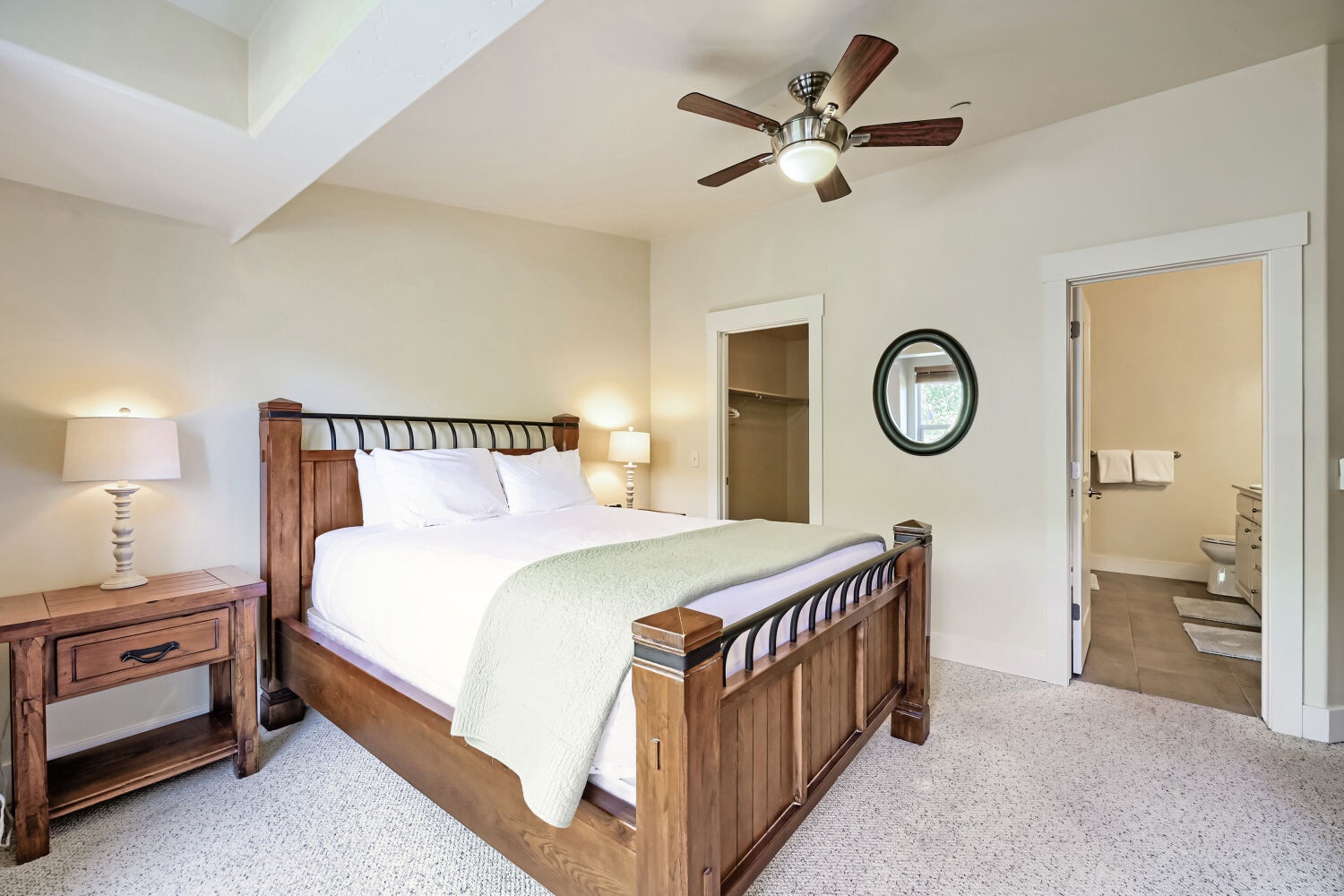 Sink into the plush bed under soft lighting and high ceilings, with your private bathroom just steps away—this tranquil retreat is designed for your restful escape.